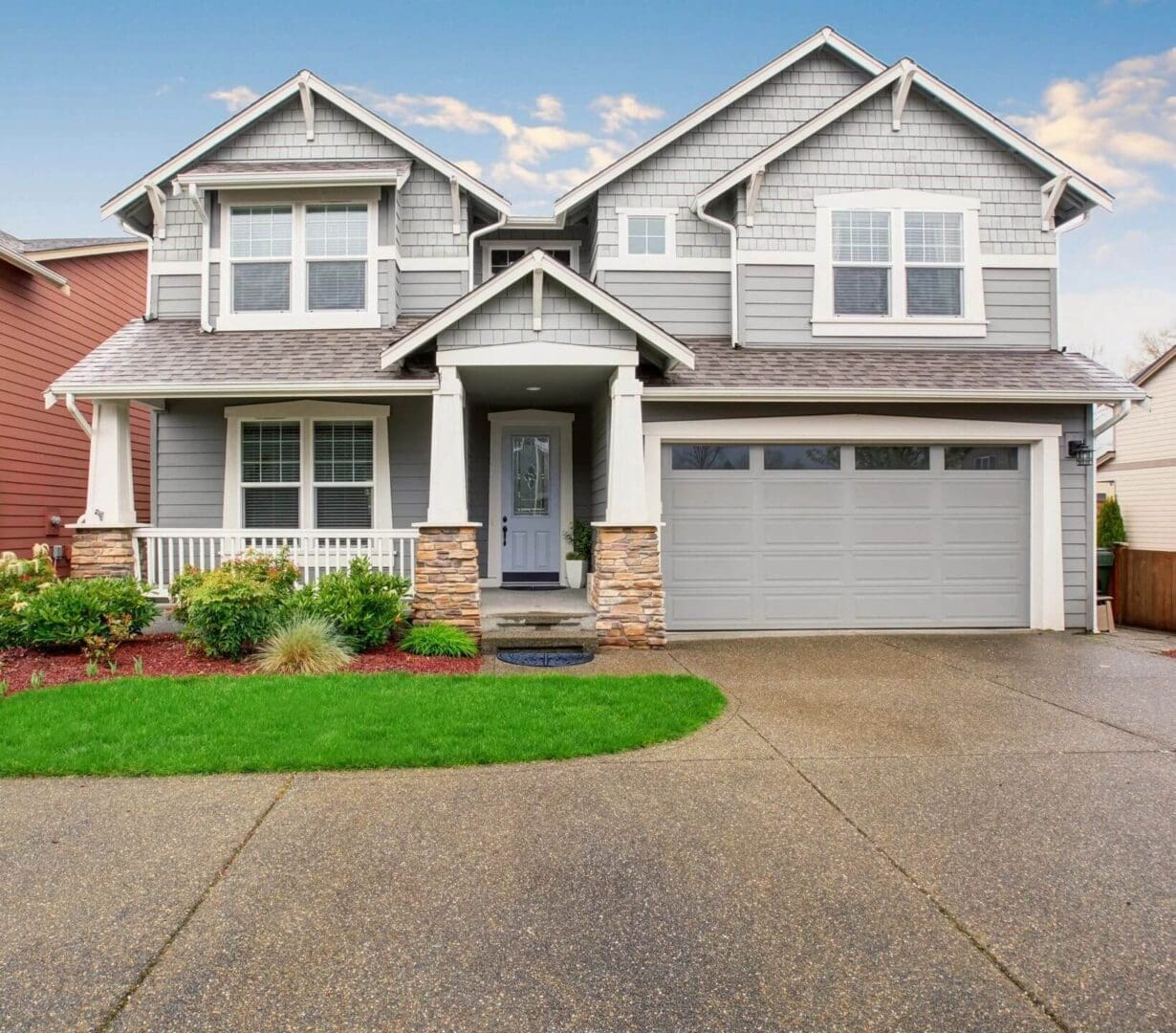 A large house with a driveway and lawn.