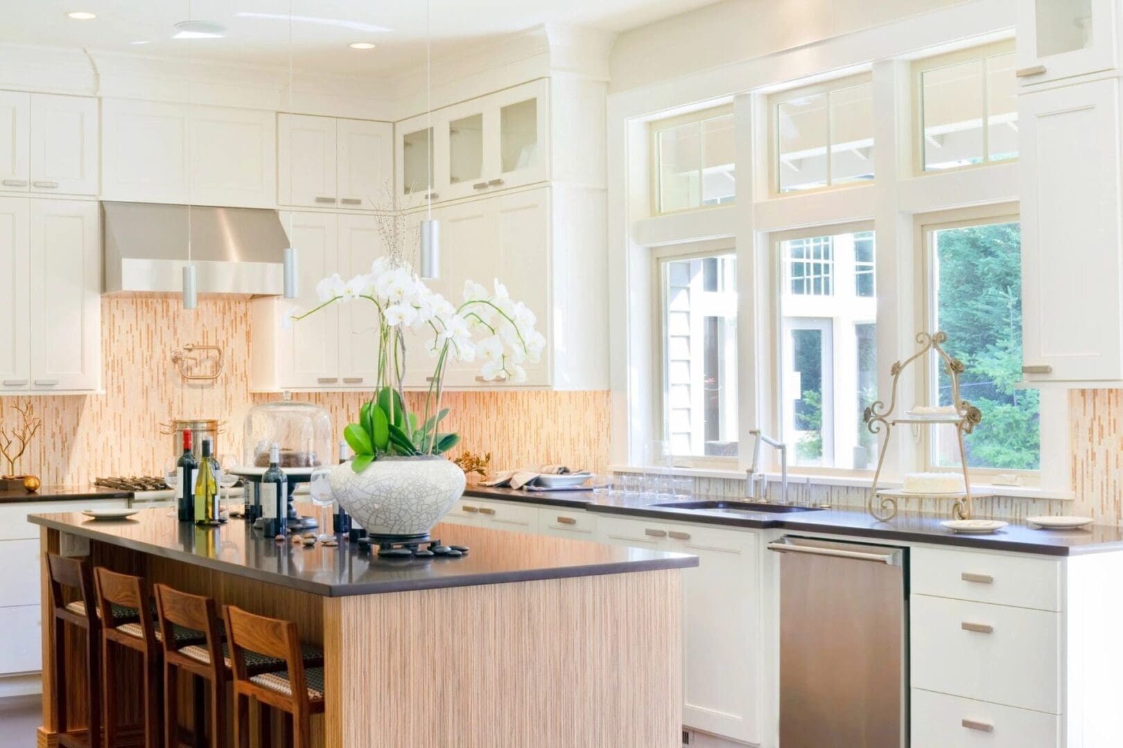 A kitchen with white cabinets and black counter tops.